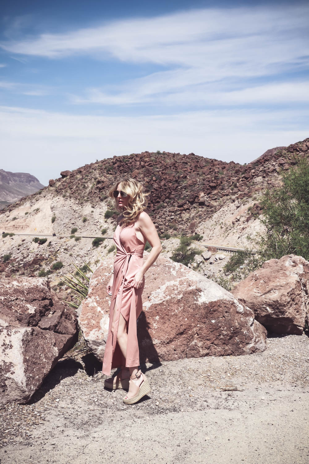 Wrap Dress by Wyldr from Asos and Revolve in blush nude color with Marc Fisher perforated ankle strap espadrilles wedges, on fashion blogger and fashion youtuber erin busbee of busbestyle, san antonio, texas, shot near Big Bend National Park in West Texas along the Rio Grande, women's dress ideas