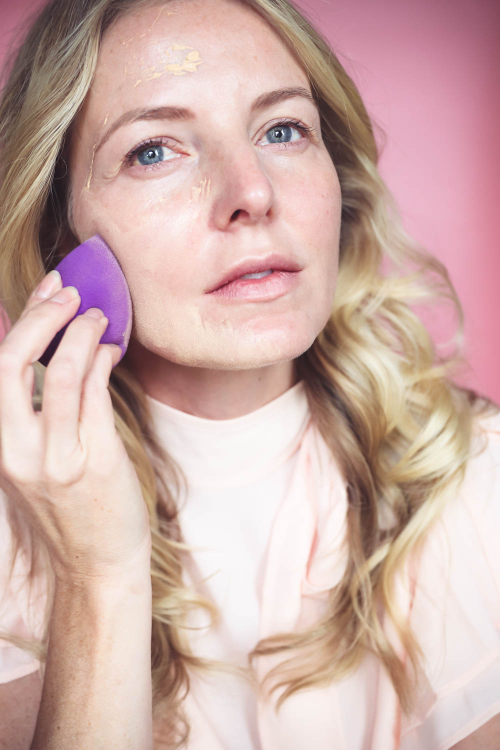 Makeup Brushes Every Woman Should Own | Using a purple beauty blender to sheer out foundation for a more air brush like finish