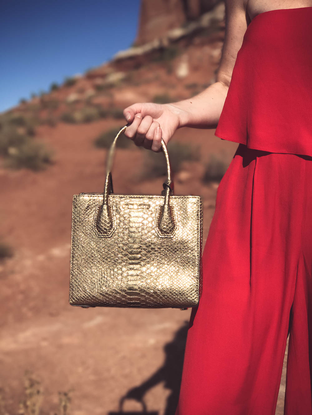 Wedding Guest Outfit Ideas,Red Wide Leg Pants and Strapless Matching Cropped Top by Free People with python embossed gold crossbody bag by Michael Kors in Moab, Utah on Fashion Blogger Erin Busbee
