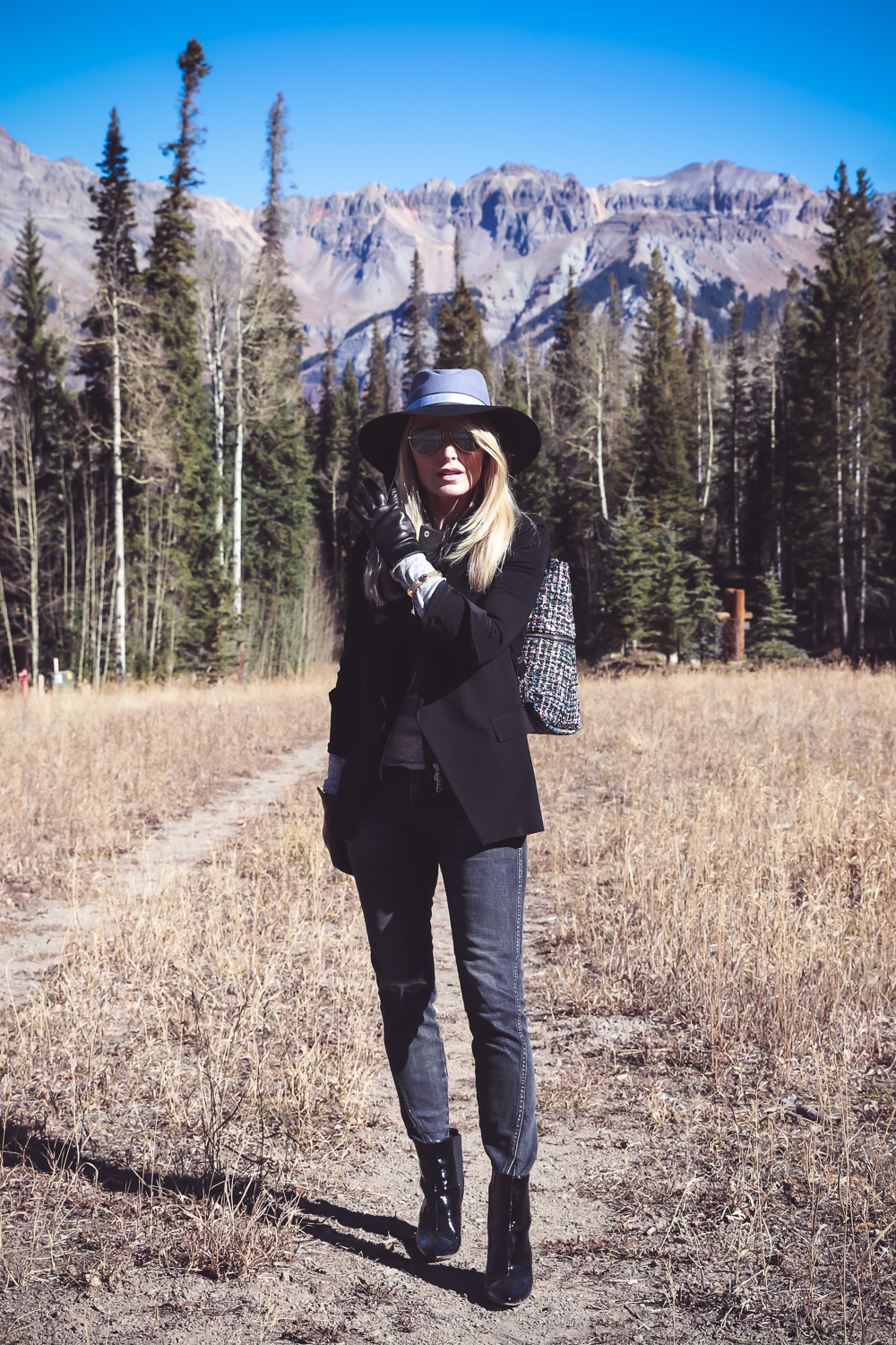 Styling Hats for women for fall and winter, featuring a Henri Bendel felt hat, paired with a jetsetter tweed backpack, veronica beard blazer with leather dickey and amo twist jeans with vince camuto patent booties on fashion blogger over 4o from Busbee Style Erin Busbee