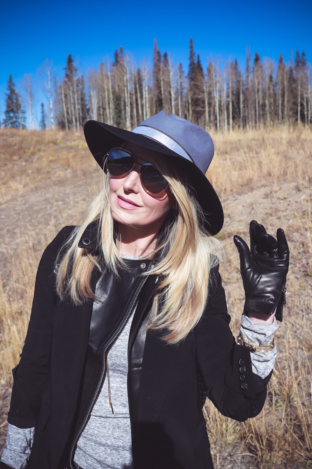 How to style a hat in the fall and winter for women, featuring accessories from Henri Bendel like this felt hat, aviator sunglasses, adjustible lariat necklace and black leather gloves, along with a gold bangle bracelet