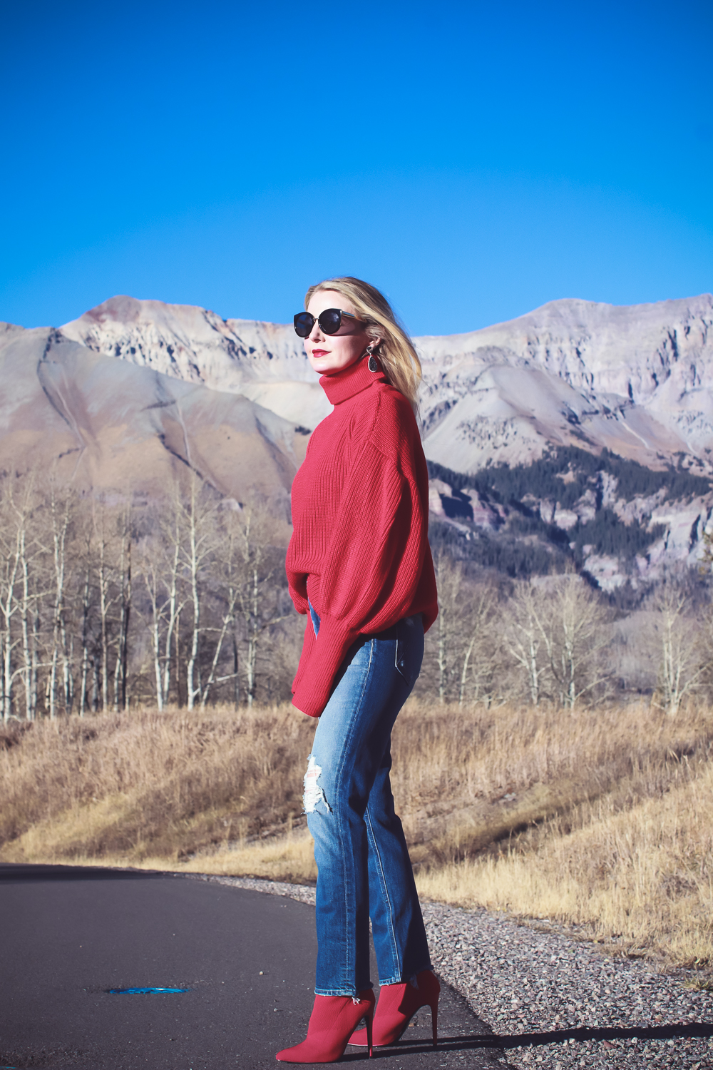 Sock Booties, what are they, how to style sock booties, featuring these red Steve Madden sock booties, Mother dazzler jeans, and a red oversized topshop turtleneck sweater on fashion blogger over 40, Erin Busbee of Busbee Style in Telluride Colorado