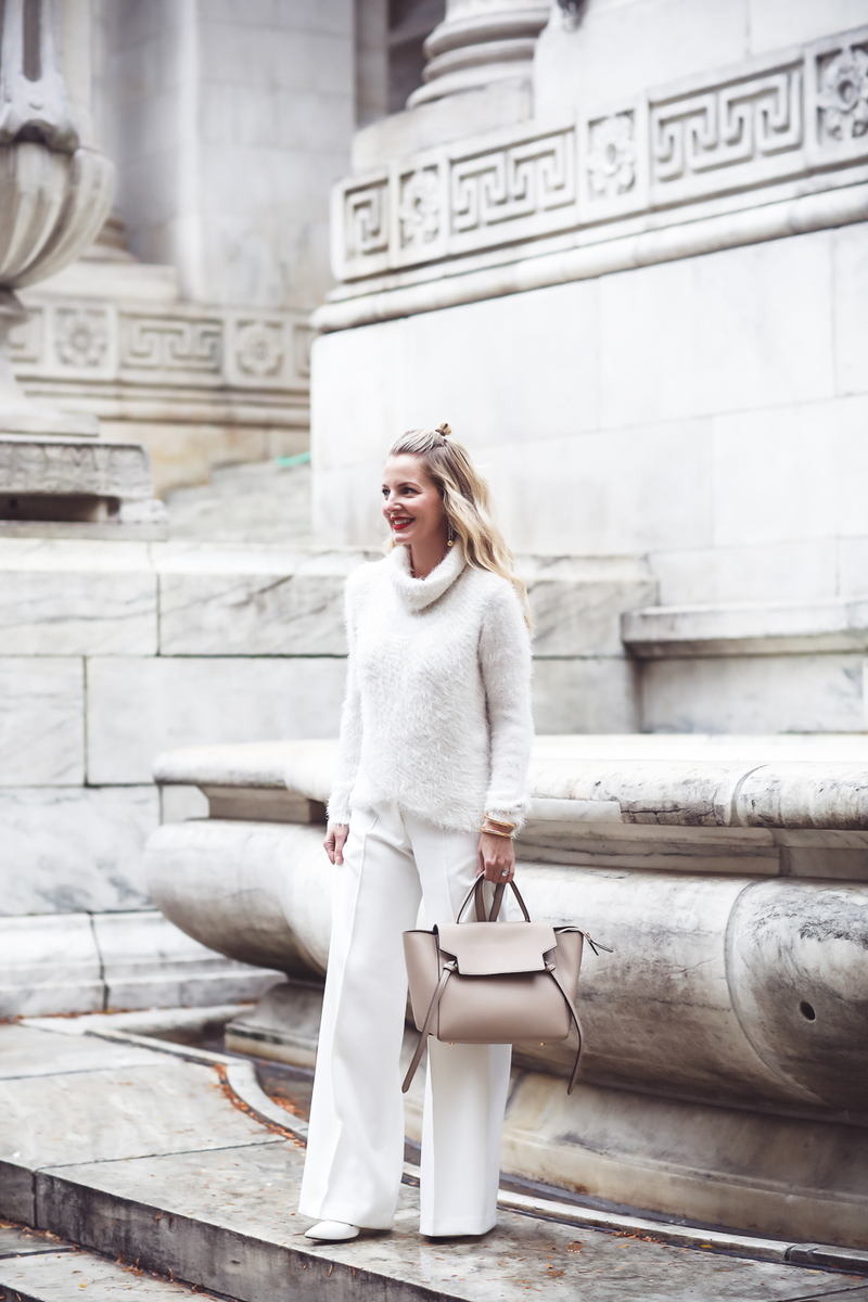 How to wear all white and still look slim, winter white, Fashion blogger Erin Busbee of Busbee Style in NYC wearing white wide leg trousers by Milly and a fuzzy white sweater with Celine belt bag and who what wear white target mules