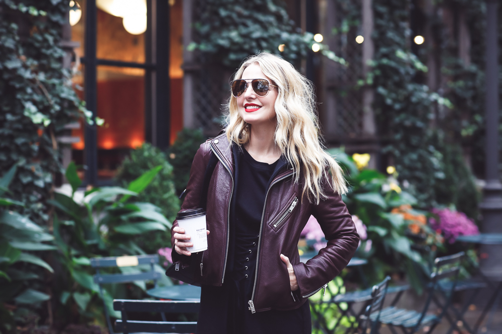 Sweatshirt Dress with corset waist in black by Socialite paired with a Doma leather hooded moto jacket in burgundy on Fashion Blogger over 40, Erin Busbee of Busbee Style at Bryant Park in New York City