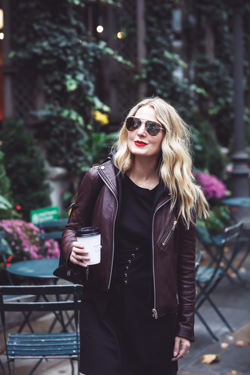 Sweatshirt Dress with corset waist in black by Socialite paired with a Doma leather hooded moto jacket in burgundy on Fashion Blogger over 40, Erin Busbee of Busbee Style at Bryant Park in New York City