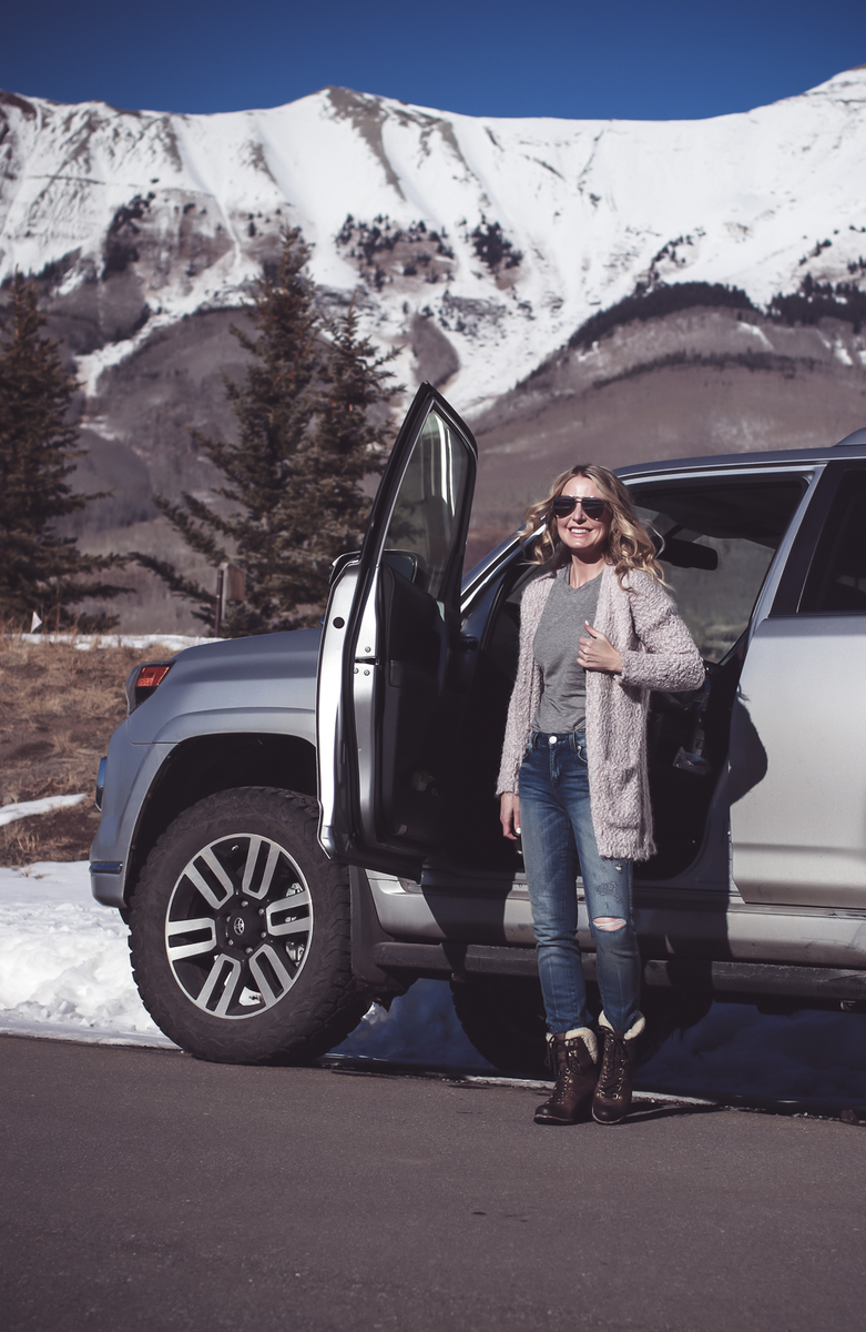 Fuzzy Cardigan sweater paired with Sorel Conquest boots, AMO twist jeans, on fashion blogger over 40, Erin Busbee of Busbee Style in Mountain Village, Telluride Colorado in front of Toyota 4-runner limited