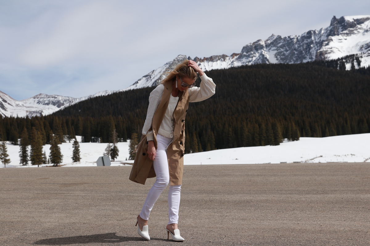 Erin Busbee wearing white jeans, sleeveless trench from Target, white Vince Camuto mules, and white corset sweater, perfect light layers for spring
