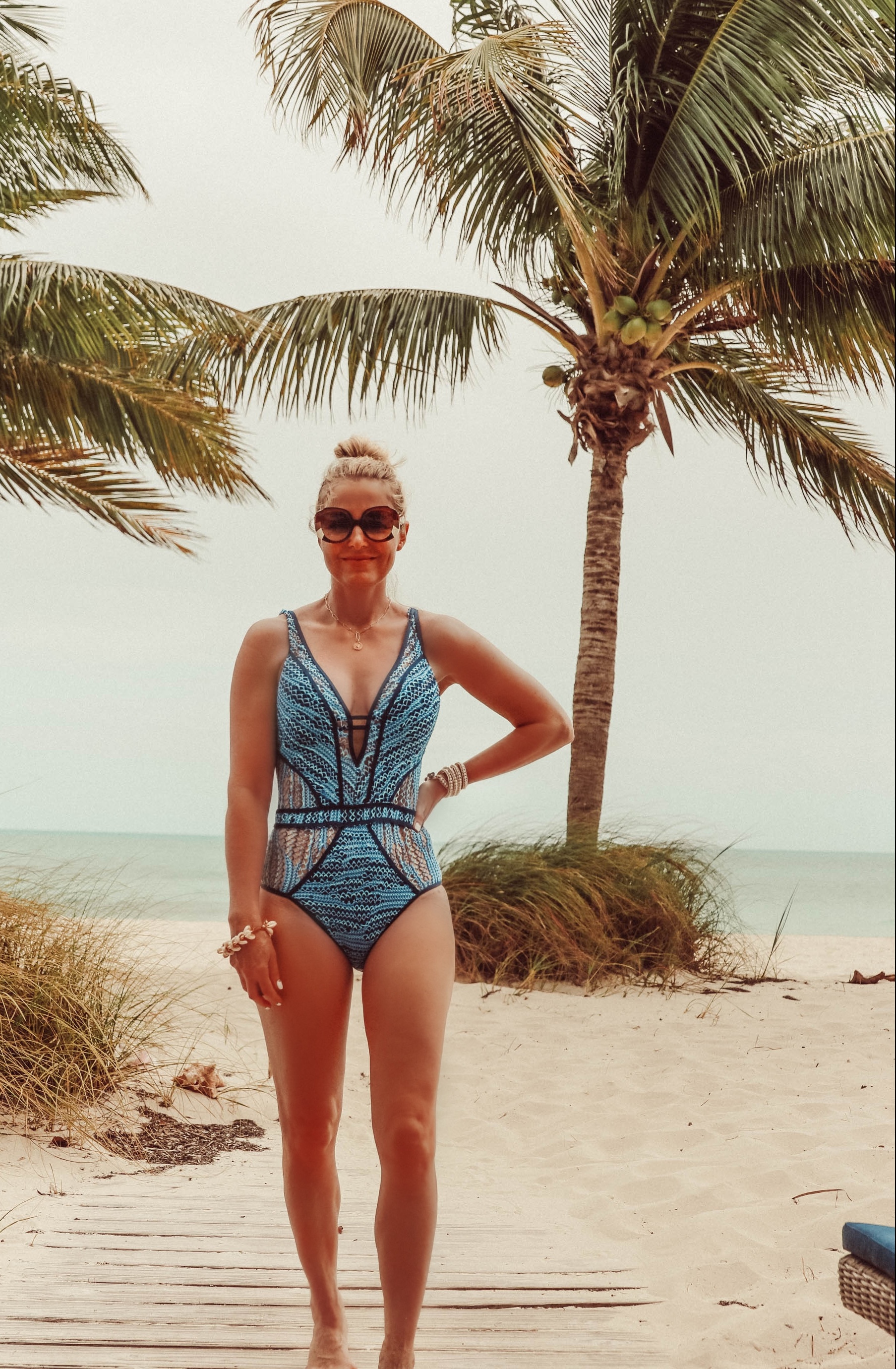 Flattering Swimsuits, Fashion blogger Erin Busbee of BusbeeStyle.com wearing a blue Becca one piece with plunge neckline in the Bahamas