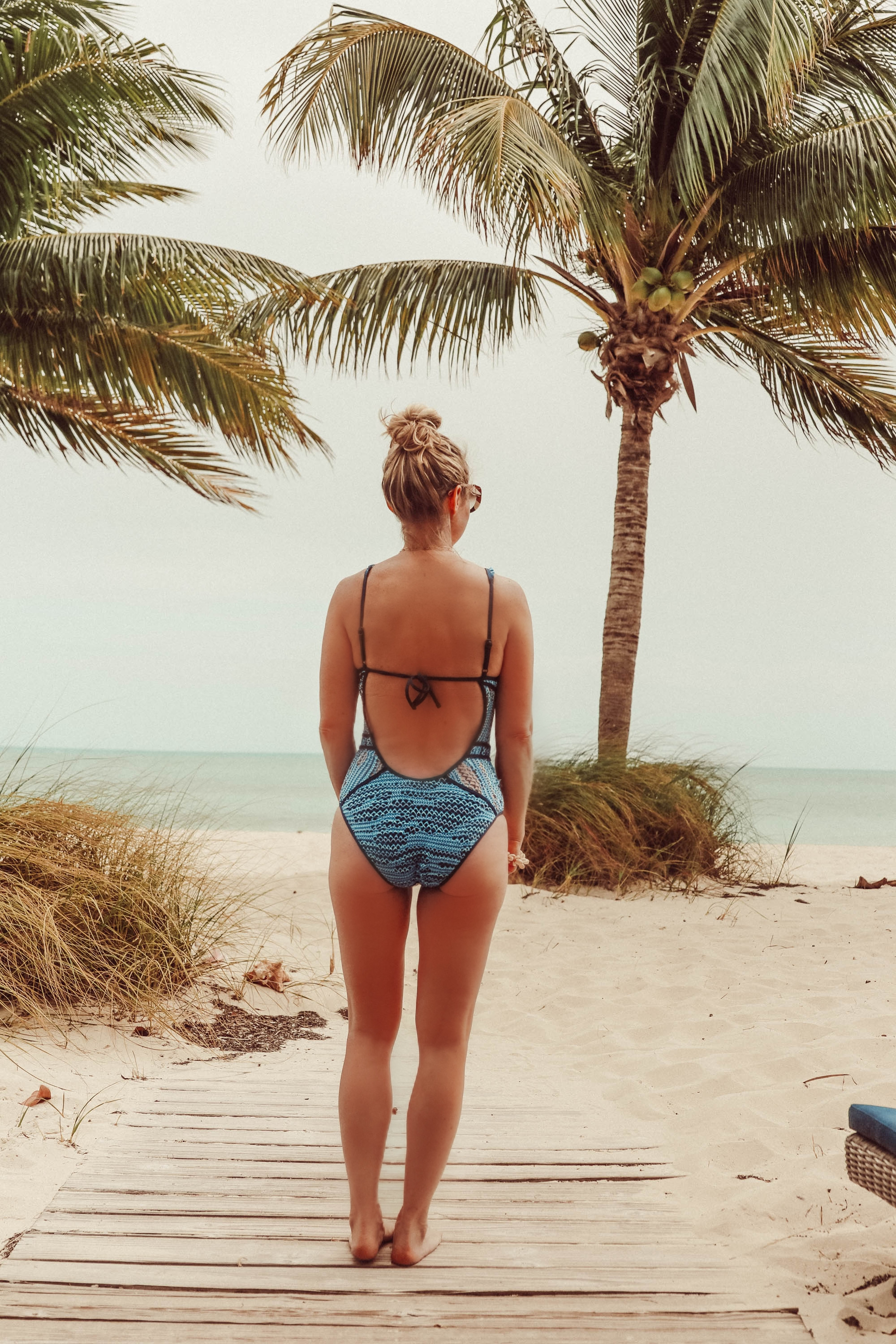 Flattering Swimsuits, Fashion blogger Erin Busbee of BusbeeStyle.com wearing a blue Becca one piece with plunge neckline in the Bahamas, Flattering Swimsuits For Women Over 40