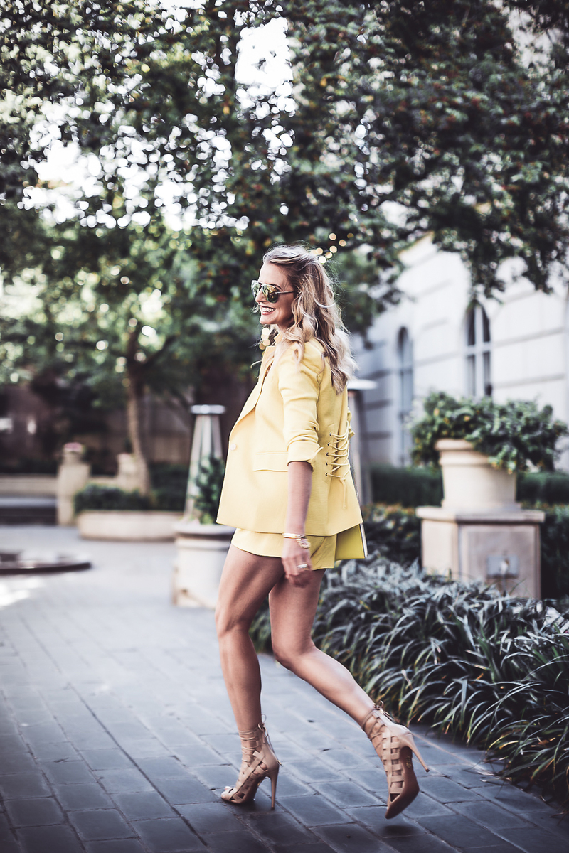 reward style blogger conference 2018, blonde fashion blogger walking in a yellow shorts suit by Veronica Beard at Hotel Crescent court carrying a Henri Bendel Rivington pouch in bright yellow