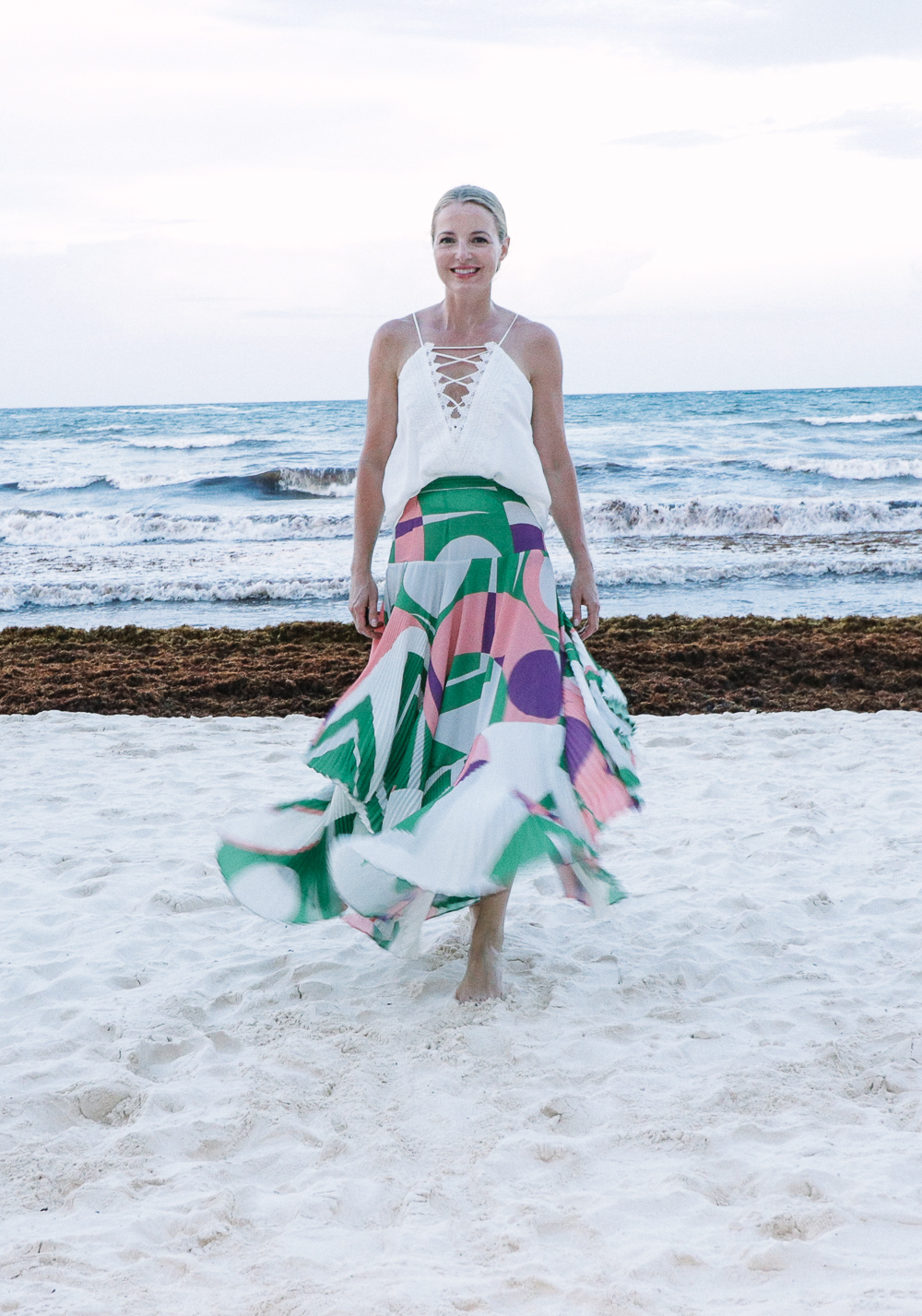 Maxi Skirts, my picks including this gorgeous pleated pink and green maxi skirt by Alexis paired with a WAYF lace up cami in white on the beach in Tulum, Mexico, best beach vacation outfits