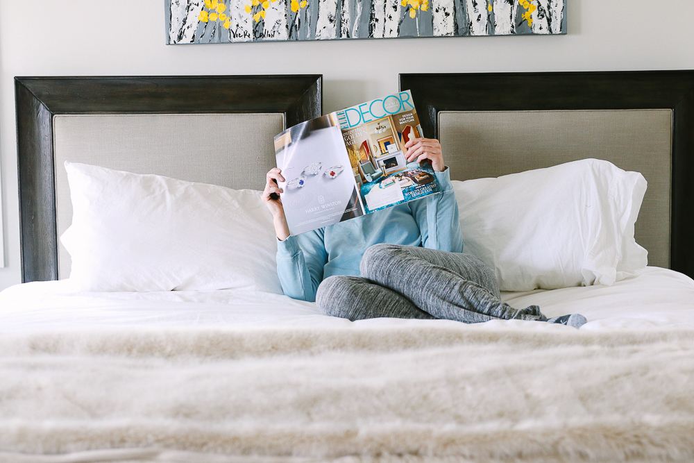 King Headboard mixing linen with solid wood in a modern home blond woman reading magazine on bed