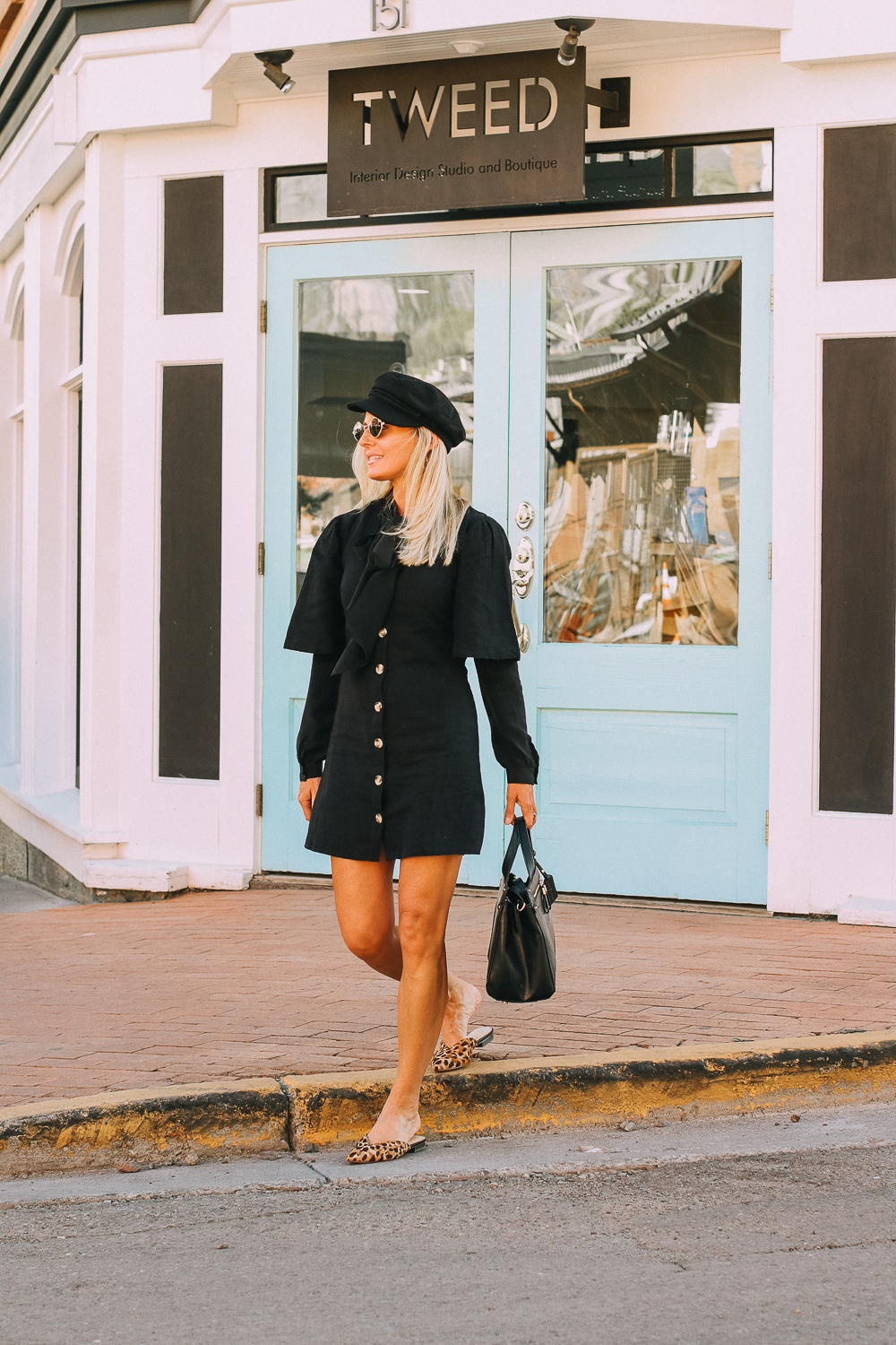 Vegan Leather Handbag by Sole Society paired with black Topshop dress, bow blouse, and newsboy cap on fashion blogger Erin Busbee of BusbeeStyle.com in Telluride, Colorado with small Quay sunglasses