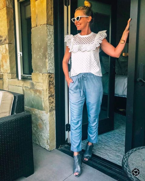 blonde woman with hair in bun wearing blue cotton pants, white eyelet top, and vince camuto booties in telluride, colorado