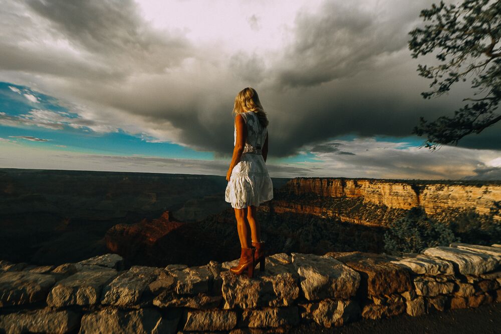 woman standing in grand canyon wearing a white dress and Saint Laurent booties, showing how to wear white after labor day