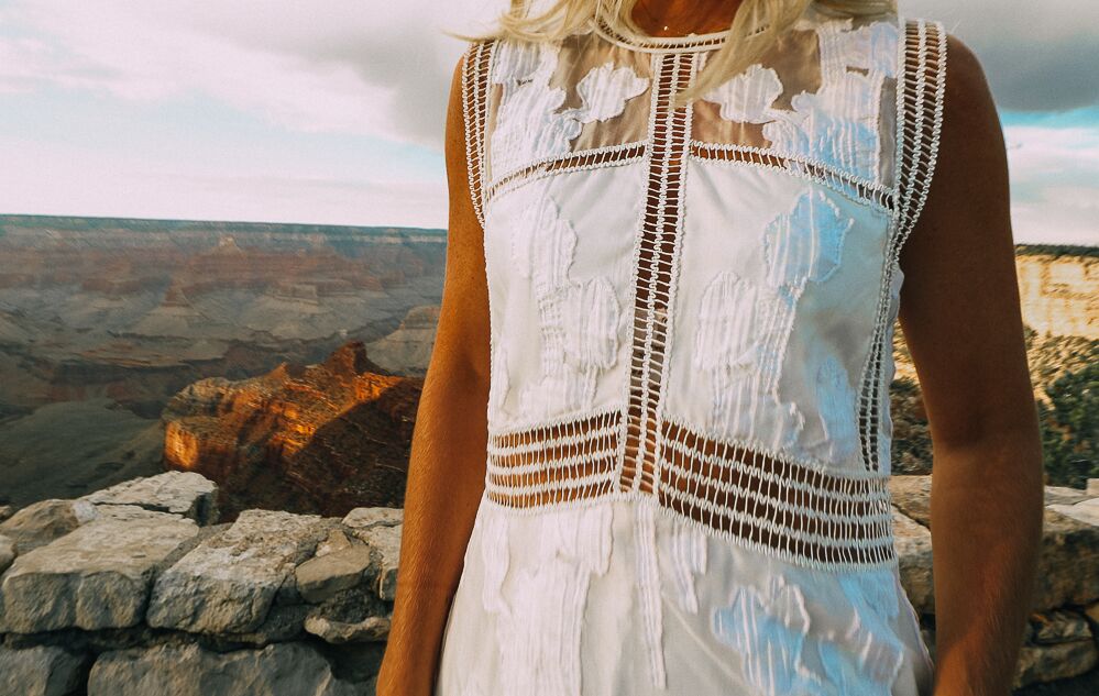 close up shot of white lace dress worn by a blonde woman in the grand canyon showing how to wear white after labor day