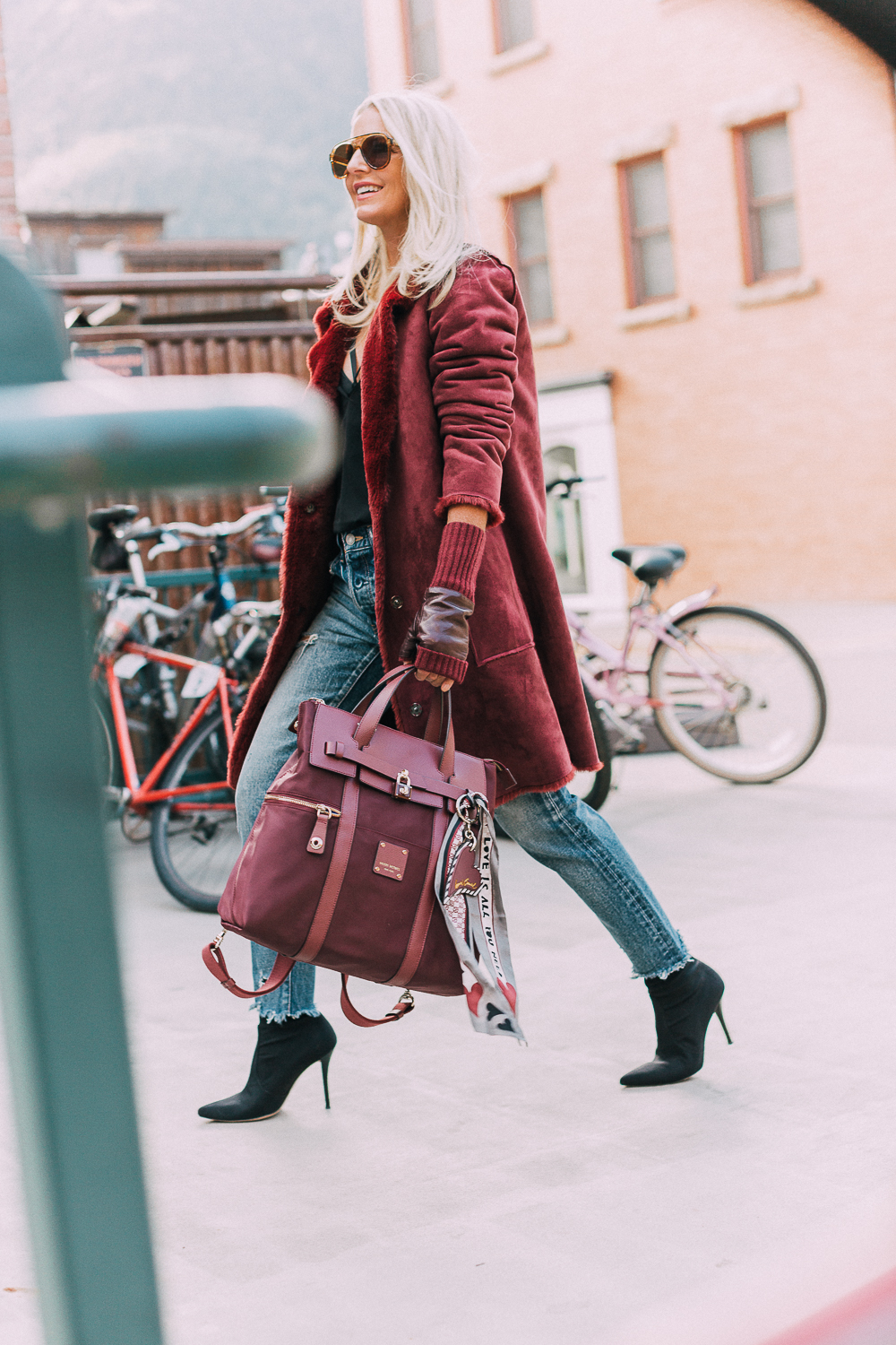 burgundy Jetsetter backpack paired with burgundy plush coat, cropped Moussy jeans, Stuart Weitzman sock booties and fingerless gloves, way to look chic on-the-go