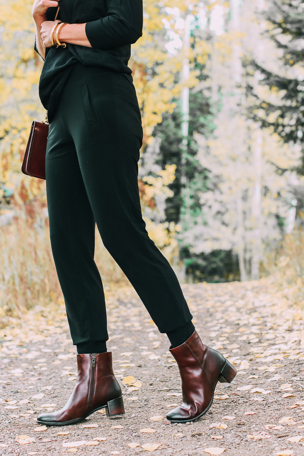 ankle boots for walking in Bison brown with low block heel and comfort, cushion technology by ECCO on fashion blogger in black joggers by Norma Kamali and black off shoulder top with brown crossbody bag