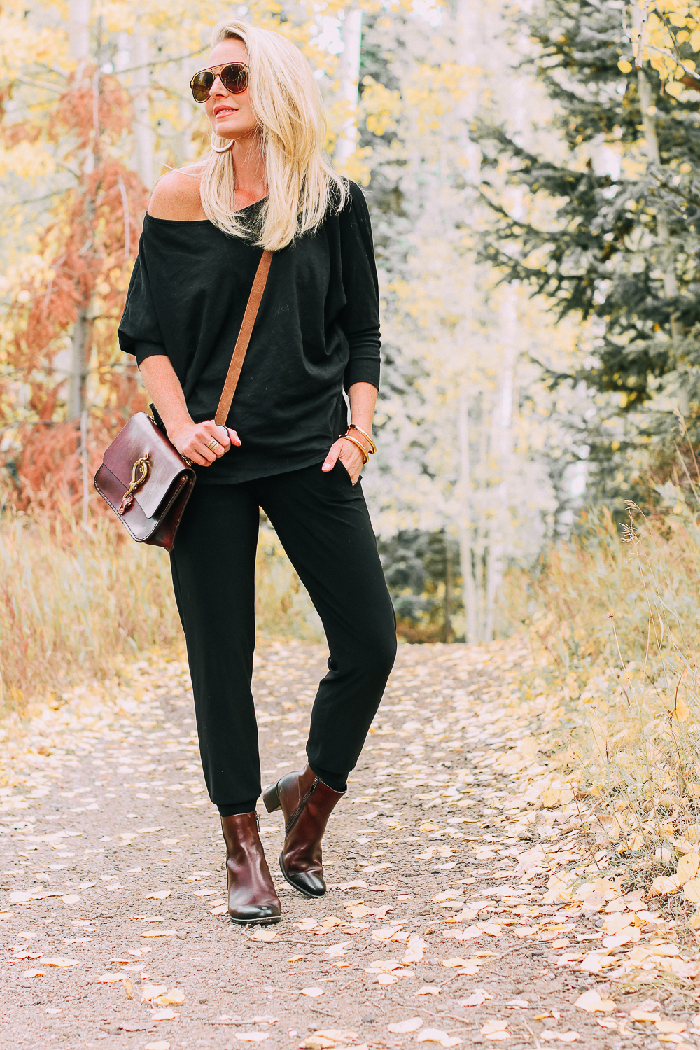 ankle boots for walking in Bison brown with low block heel and comfort, cushion technology by ECCO on fashion blogger in black joggers by Norma Kamali and black off shoulder top with brown crossbody bag