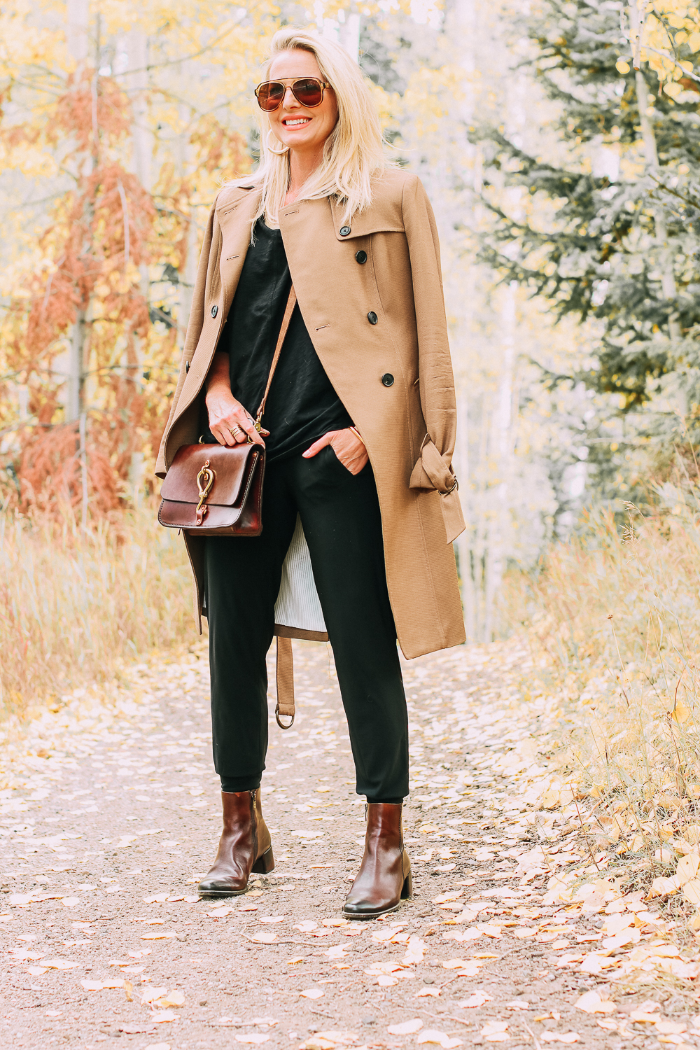 ankle boots for walking in Bison brown with low block heel and comfort, cushion technology by ECCO on fashion blogger in black joggers by Norma Kamali and black off shoulder top with brown crossbody bag