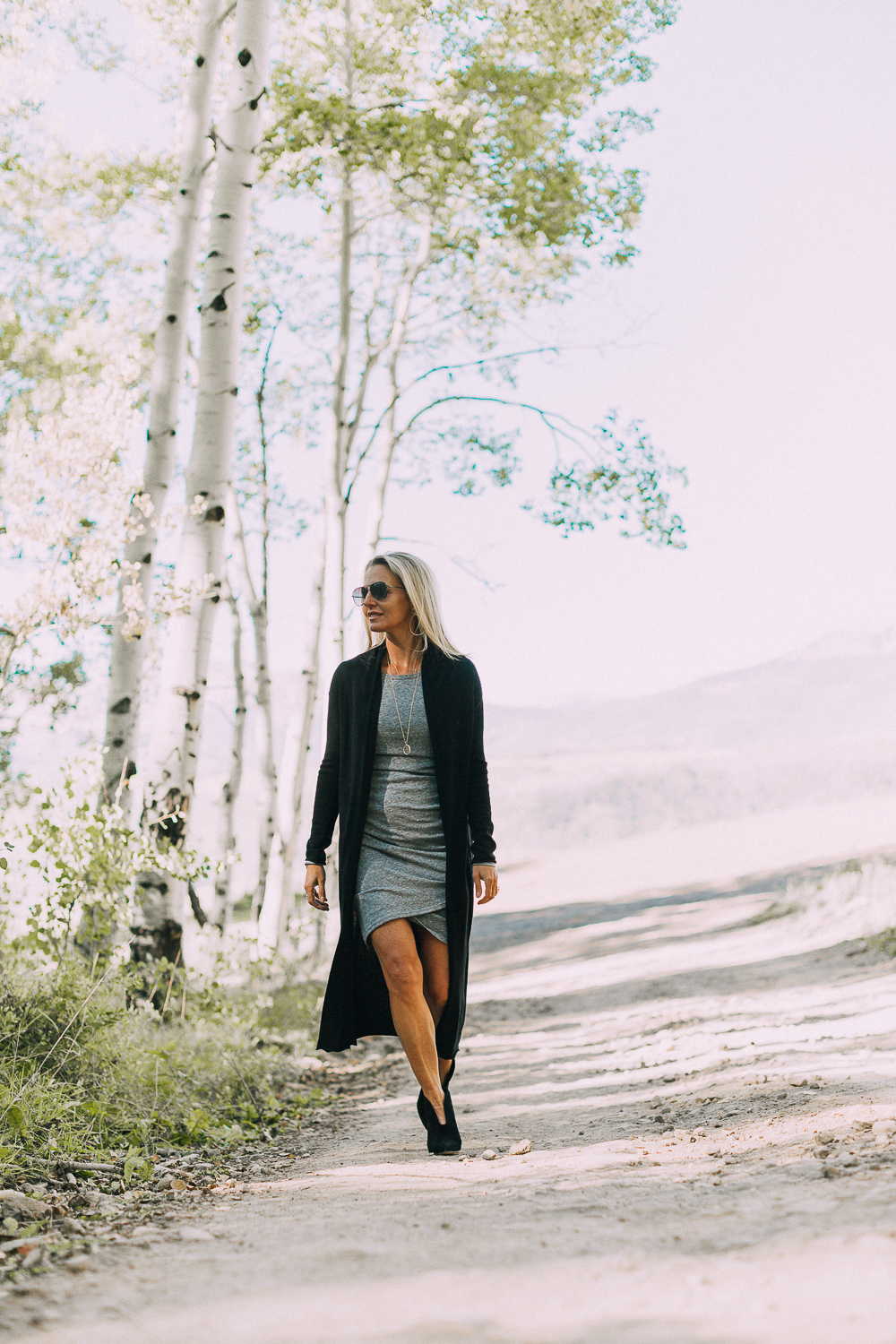 fall booties 2018 featuring black dressy booties by Vince Camuto in black suede paired with a ruched gray t-shirt dress with long sleeves and a long black cardigan sweater on fashion blogger over 40, Erin Busbee of Busbee Style