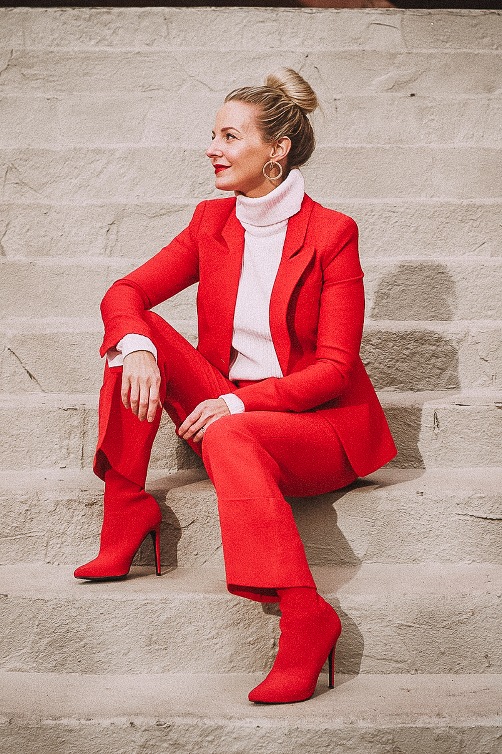Red suit by Smythe, dutchess blazer and cropped pants with red Steve Madden sock booties on blonde woman