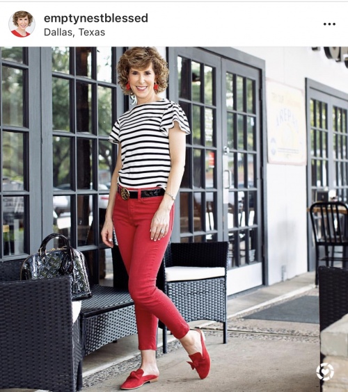 40+ style blogger emptynestblessed wears red skinny jeans, red flats, a black and white striped ruffle sleeve t-shirt and red earrings. 