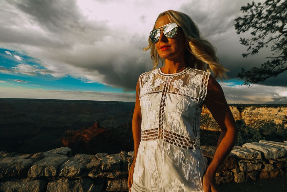 blonde woman wearing white lace dress and booties in the grand canyon