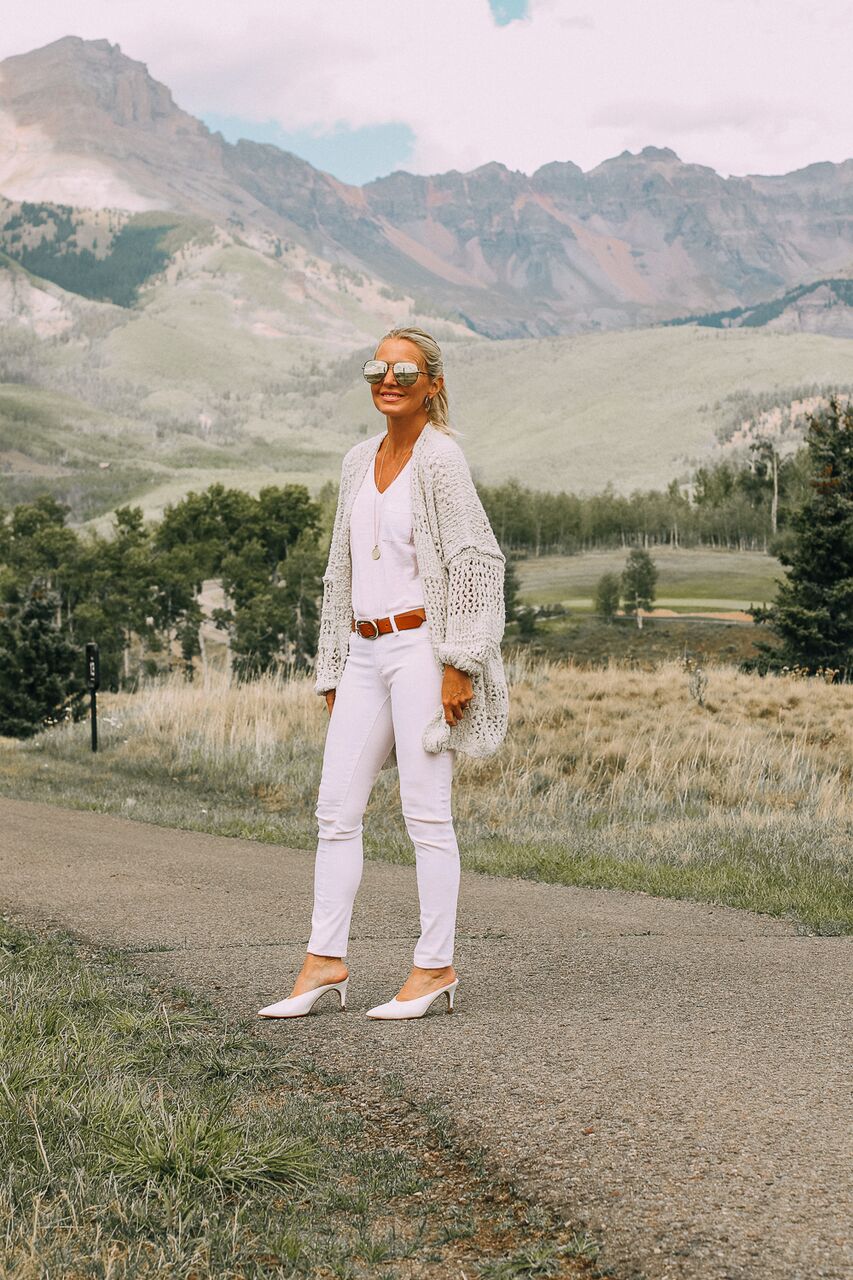 blonde woman wearing all white look with skinny jeans and cardigan from free people