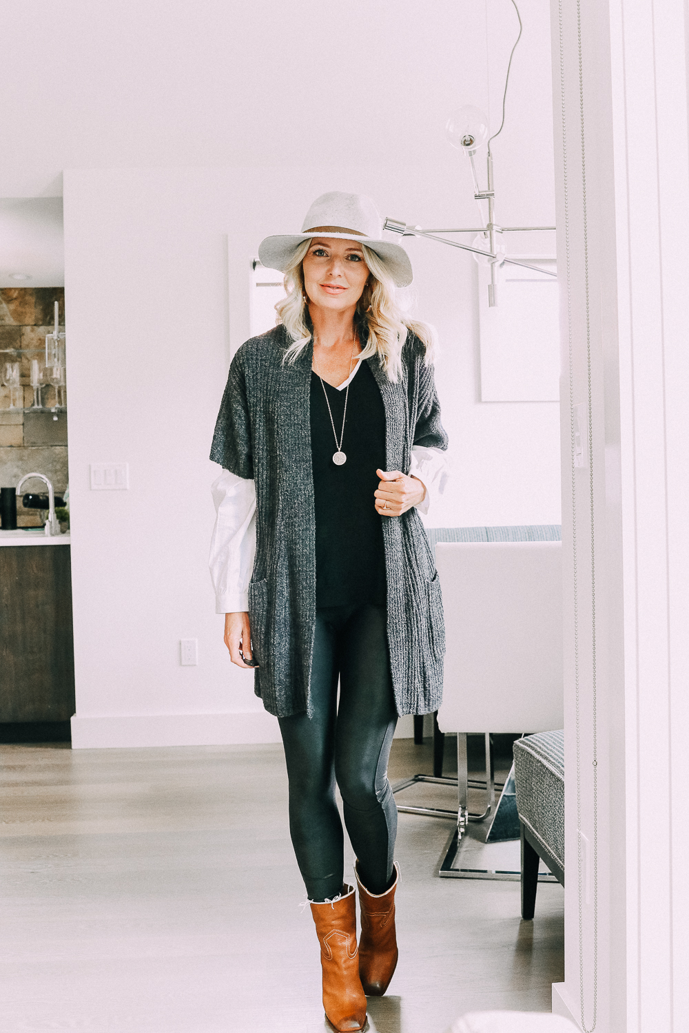 Blonde woman wearing jeans, layered sweater, Barefoot dreams cardigan, Saint Laurent boots, and a Rag & Bone hat in Telluride Colorado sharing chic and casual looks for busy moms