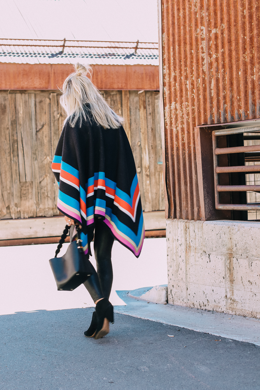 striped poncho, spanx leggings, vince camuto booties and henri bendel black bucket bag with gold hardware