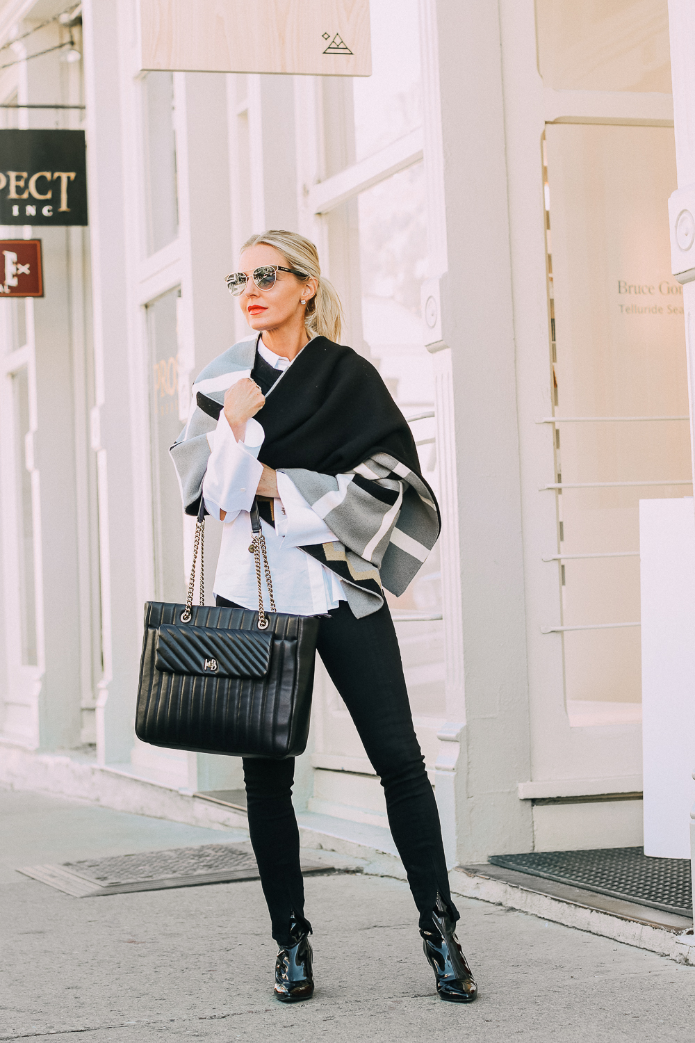 best work tote, quilted in black with chain link handles by Henri Bendel, paired with black jeans, patent leather sock booties, white Lafayette button down shirt and wrap