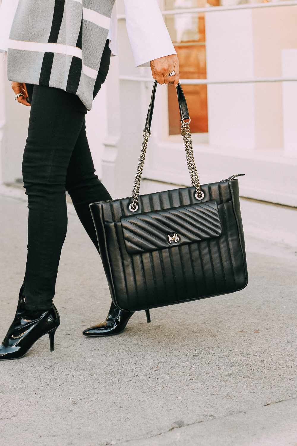 best work tote, quilted in black with chain link handles by Henri Bendel, paired with black jeans, patent leather sock booties, white Lafayette button down shirt and wrap