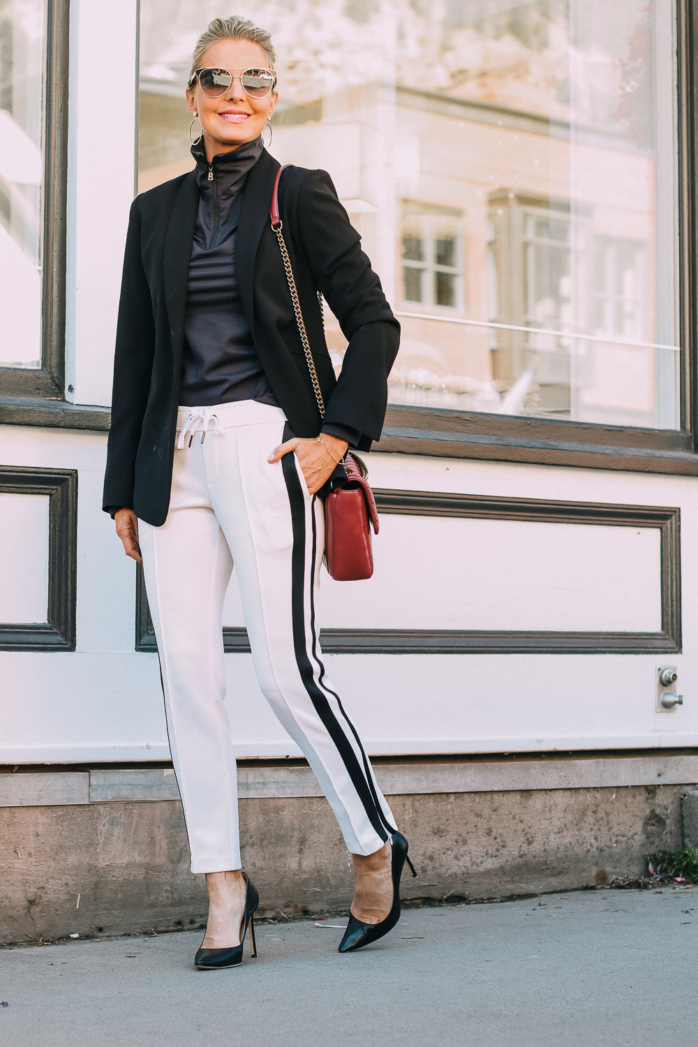 Henri Bendel quilted crossbody bag in burgundy with gold chain link detail paired with Pam & Gela striped pants, Bogner turtleneck and black blazer