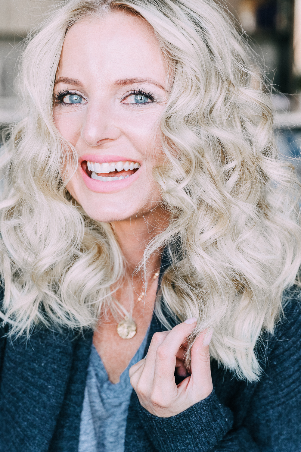 Curling your hair with a wand, step by step instructions by beauty blogger Erin Busbee with long blonde hair