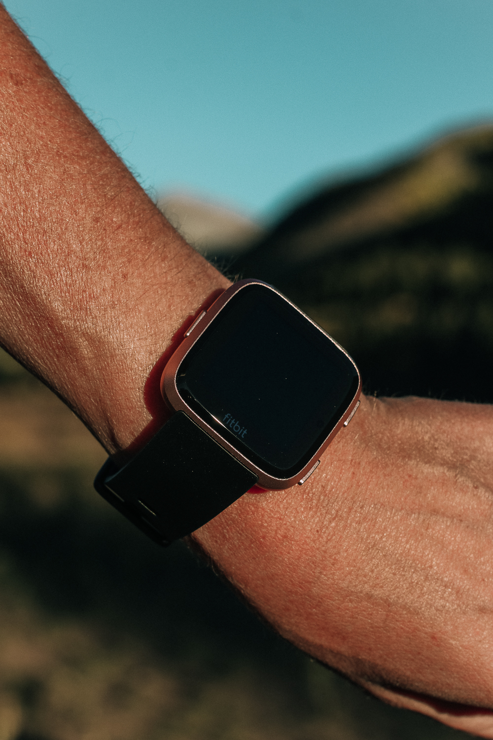 Running watch, reviewing the Fitbit Versa Smartwatch for exercise and running, blonde with Outdoor voices activewear on running in the mountains