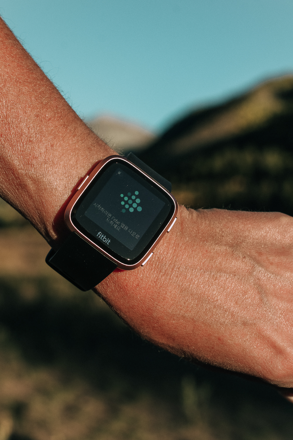 Running watch, reviewing the Fitbit Versa Smartwatch for exercise and running, blonde with Outdoor voices activewear on running in the mountains
