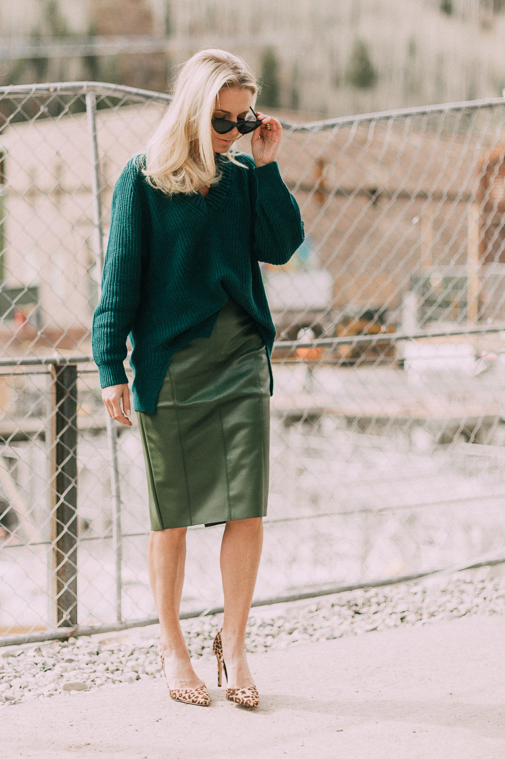 Work Outfit Ideas, what to wear to work, outfit ideas that are modern and unexpected from Express, featuring a faux leather green pencil skirt, and chunky knit tunic sweater in green, and leopard print pumps on blonde woman