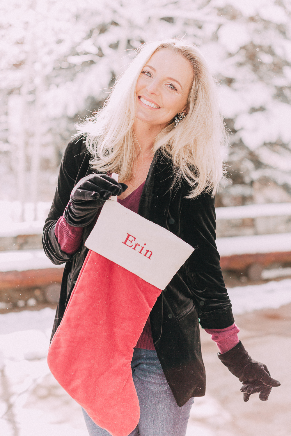 blond woman holding monogrammed christmas stocking