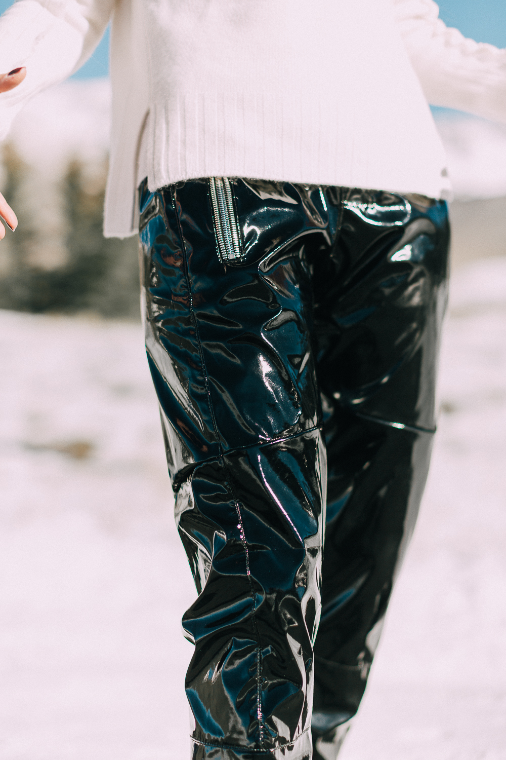Fashion blogger Erin Busbee of BusbeeStyle.com wearing black vinyl pants by RtA with a white cashmere sweater by Brochu Walker in Telluride, Colorado