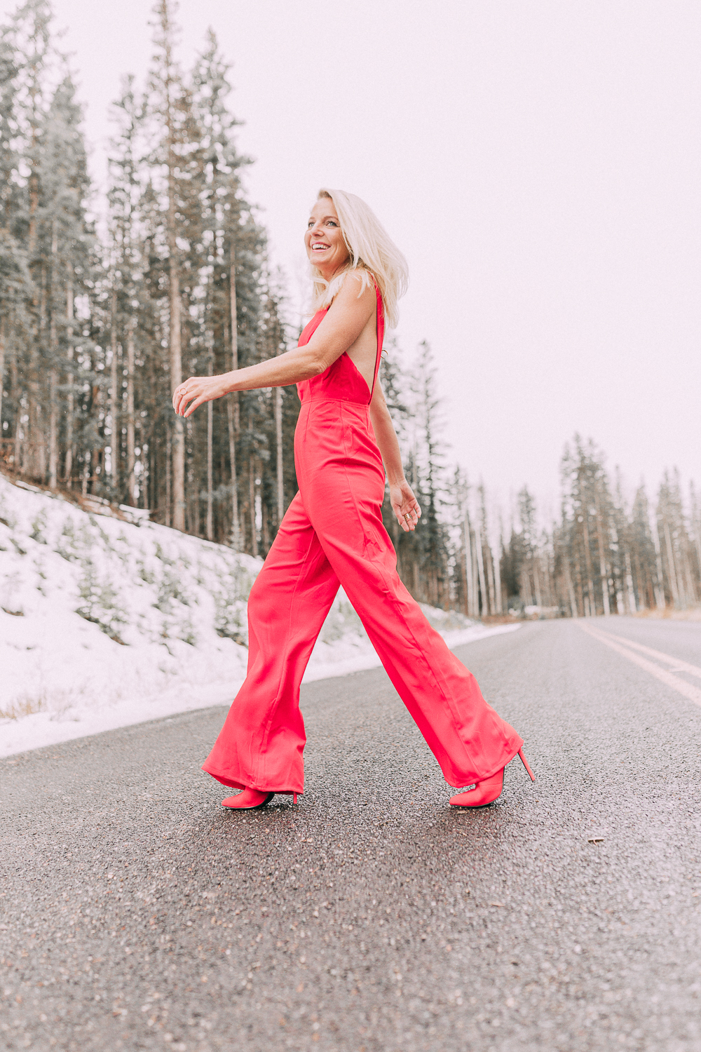 Fashion blogger Erin Busbee of BusbeeStyle.com sharing outfits for New Years Eve including this red jumpsuit by by the way. from Revolve paired with red booties