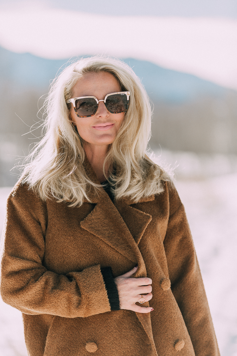 Great Fabrics make a big difference and make you feel great and this designer, Eileen Fisher, understands that featuring a brown fuzzy faux fur jacket, fuzzy black sweater, dark wash slimming jeans and western inspired booties on blonde fashion blogger over 40 in the snowy mountains