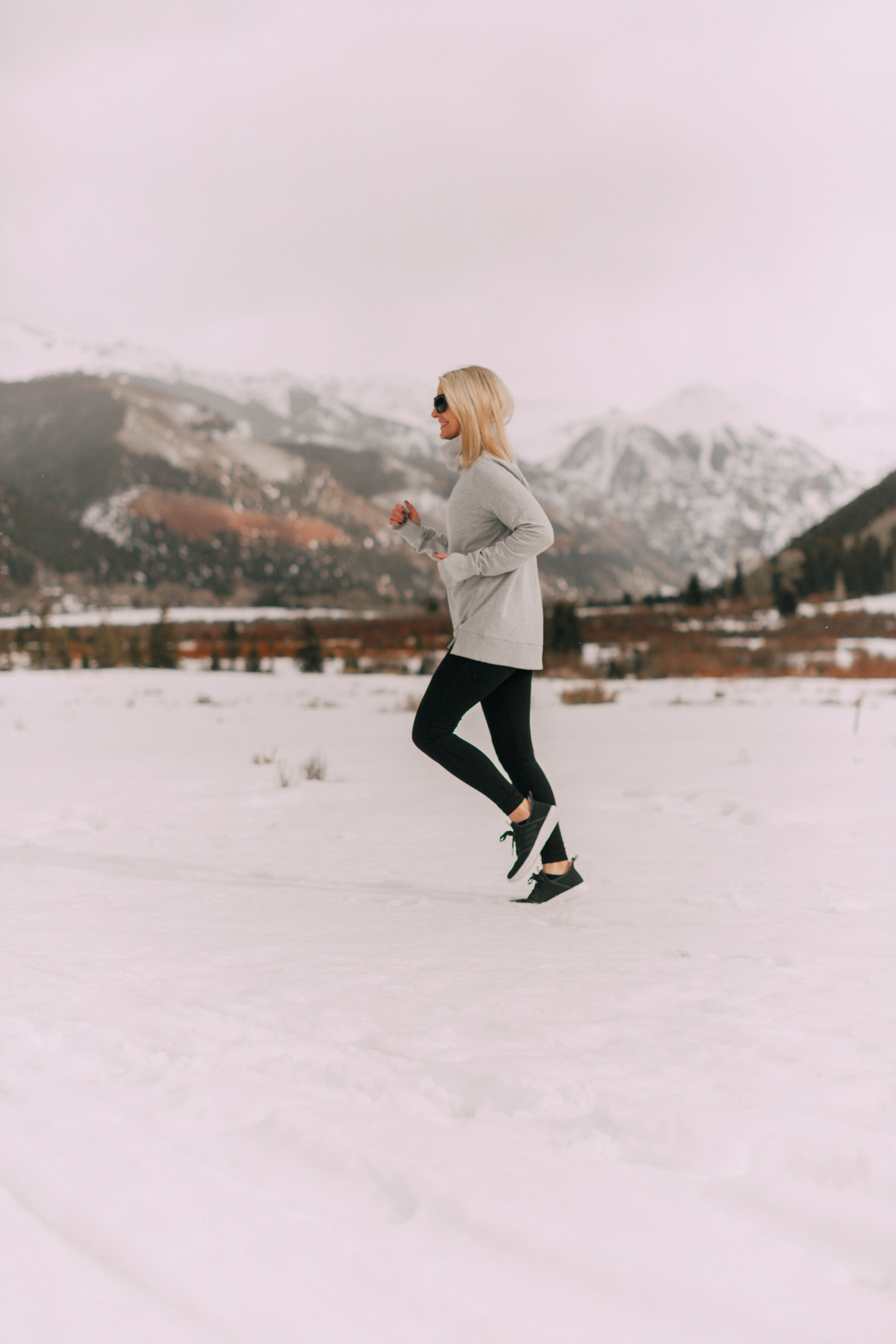 Fashion blogger Erin Busbee of BusbeeStyle.com wearing affordable activewear pieces from Jockey including their essential leggings and gray pullover in the snow, affordable activewear for women, in Telluride, Colorado