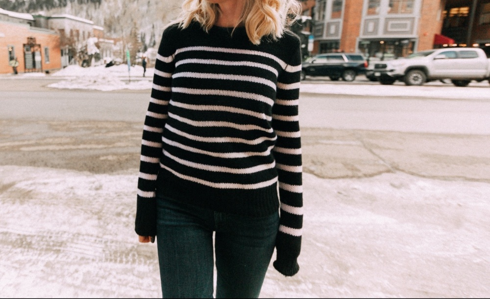 Affordable cashmere sweaters by Aqua from Bloomingdales featuring Fashion blogger Erin Busbee of BusbeeStyle.com wearing a navy and white striped cashmere sweater with dark wash high rise Mother jeans and black western inspired tall boots by Schutz
