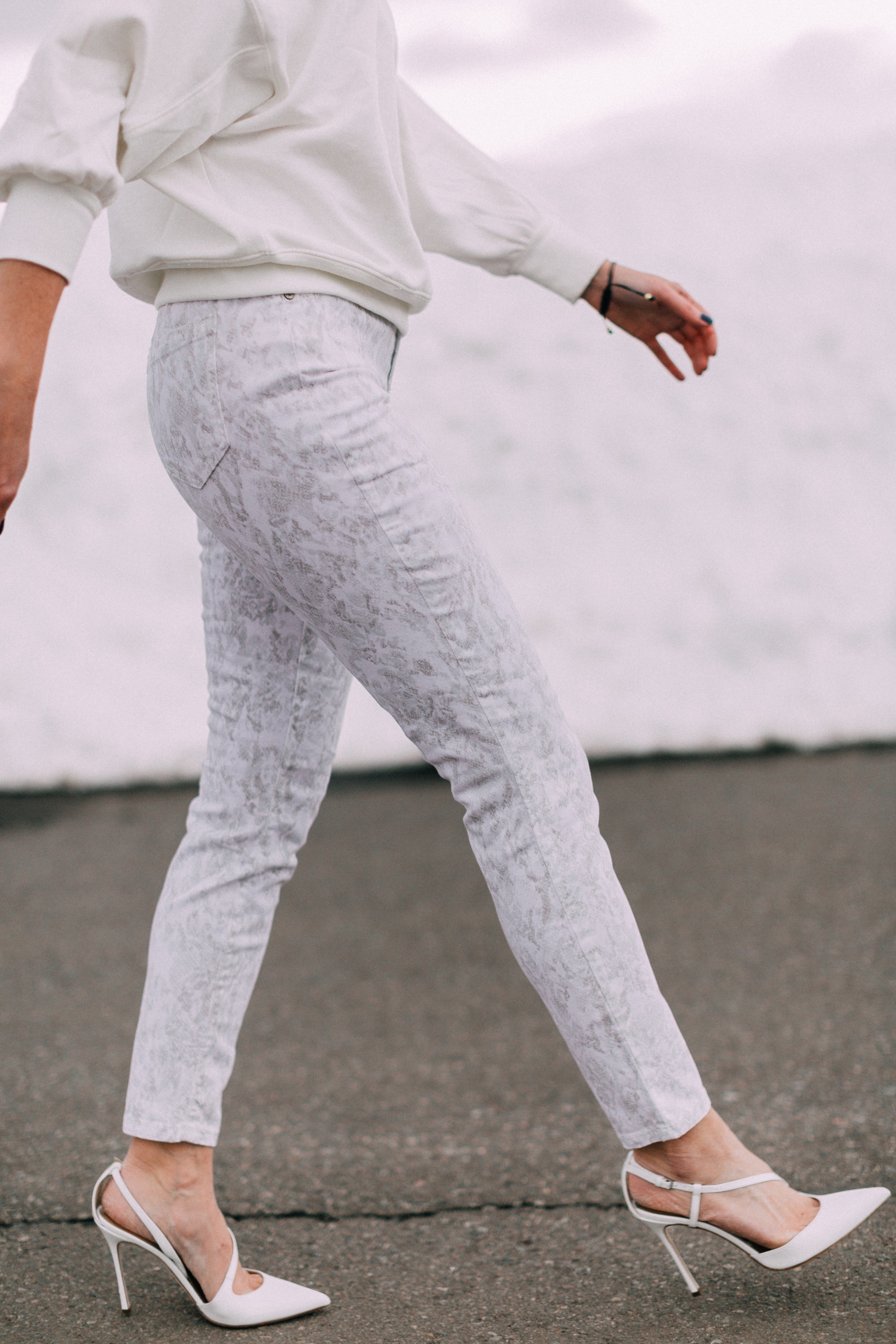 fashion blogger wearing walmart sofia vergara white snakeskin jeans white open back sweatshirt white slingback pumps
