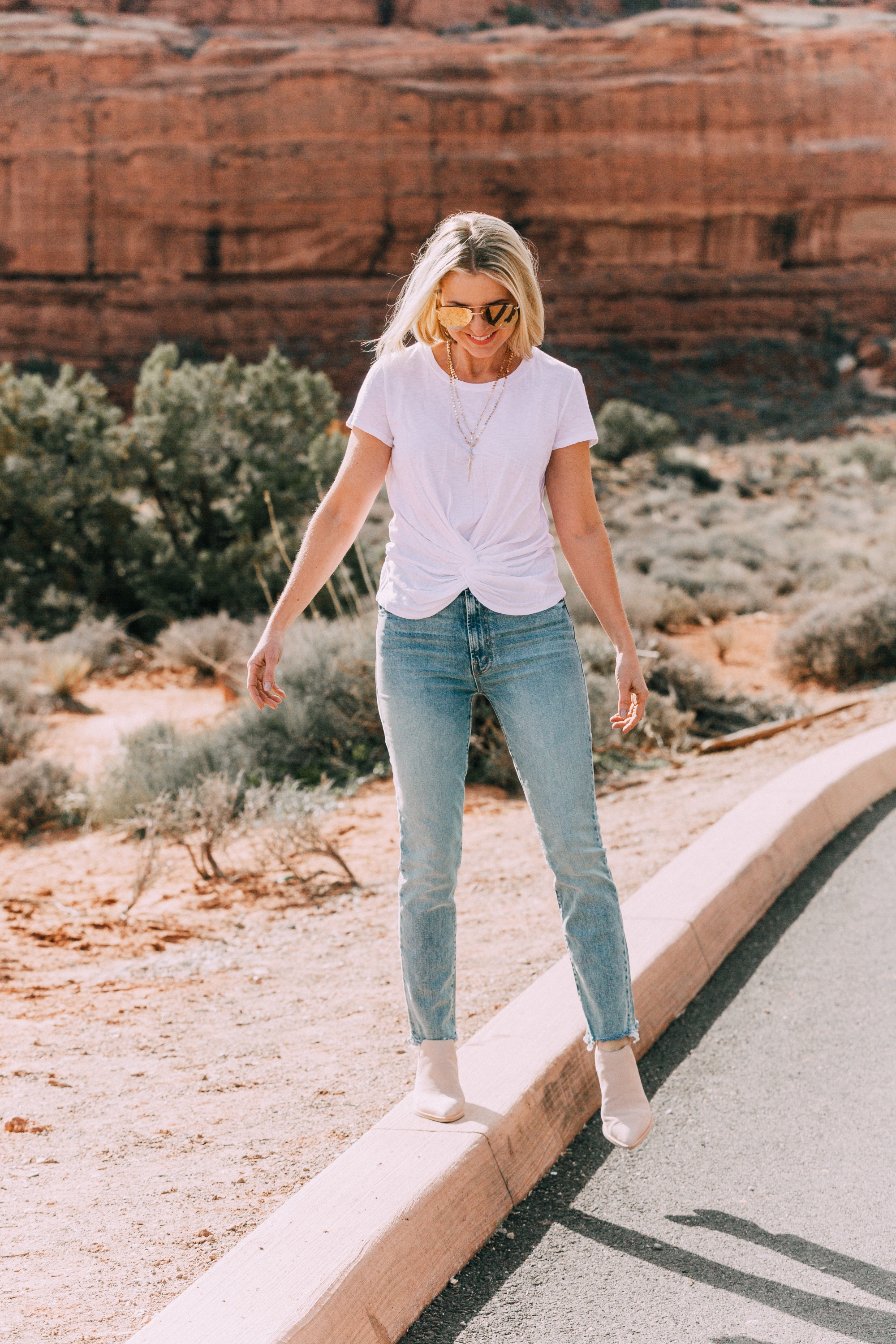 fashion blogger over 40 wearing white twist front t shirt and Mother brand The Rascal blue jeans