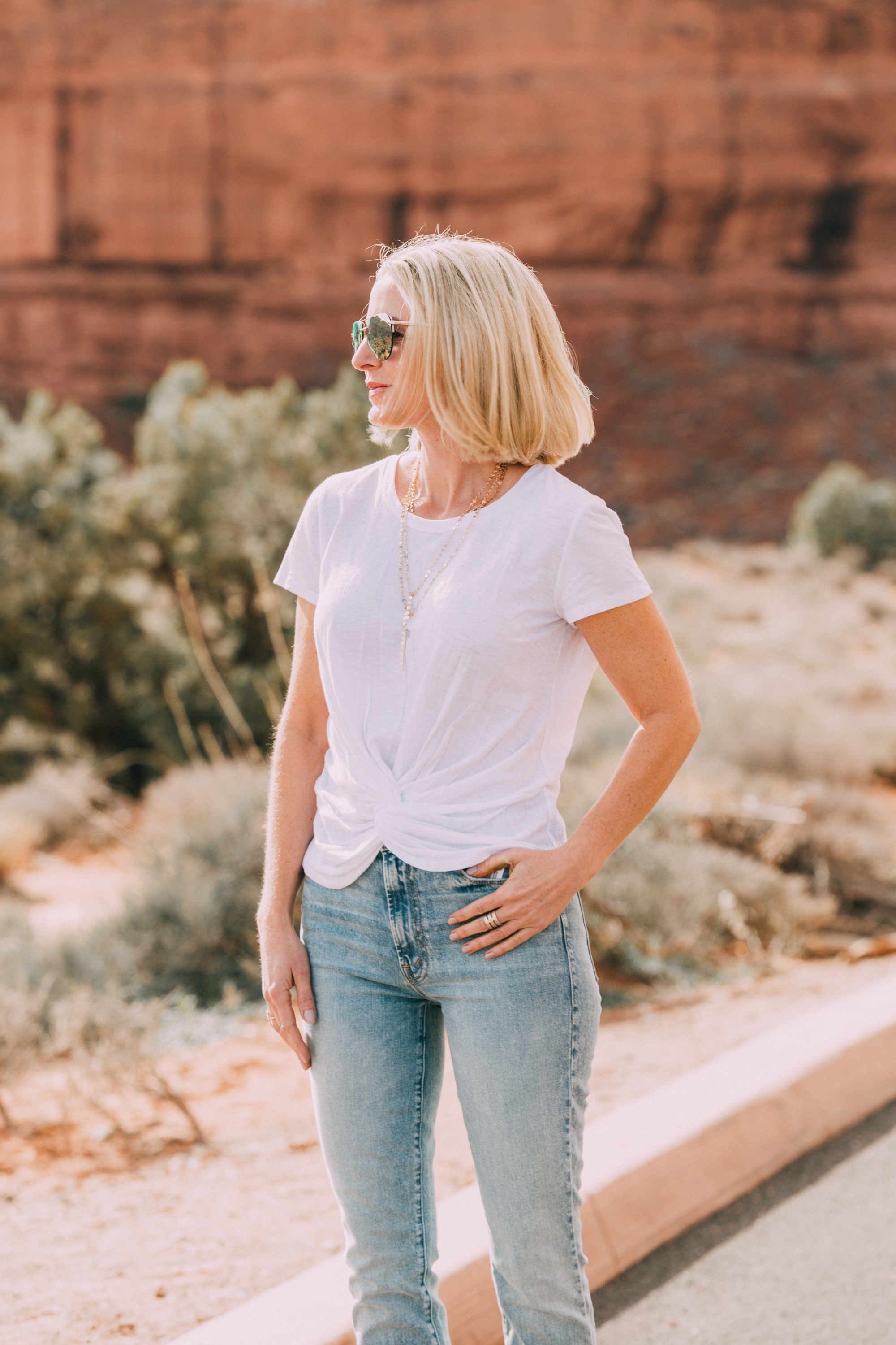 fashion blogger over 40 wearing Aqua twist front knot white t shirt from bloomingdales with mother jeans