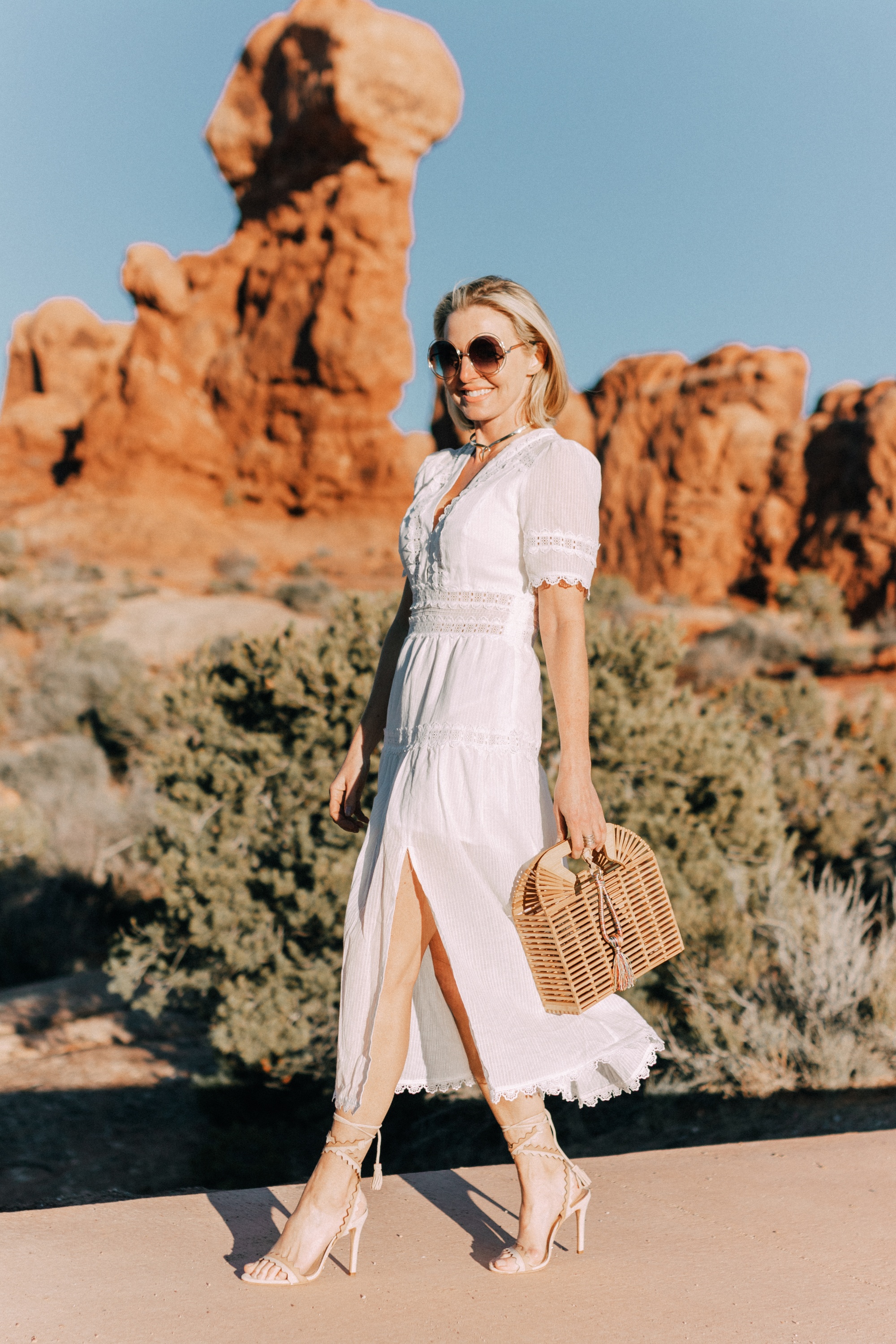 White dresses for spring and summer, white midi WAYF lace dress with sleeves paired with Schutz nude sandals and a natural basket bag by Vince Camuto, affordable white dresses