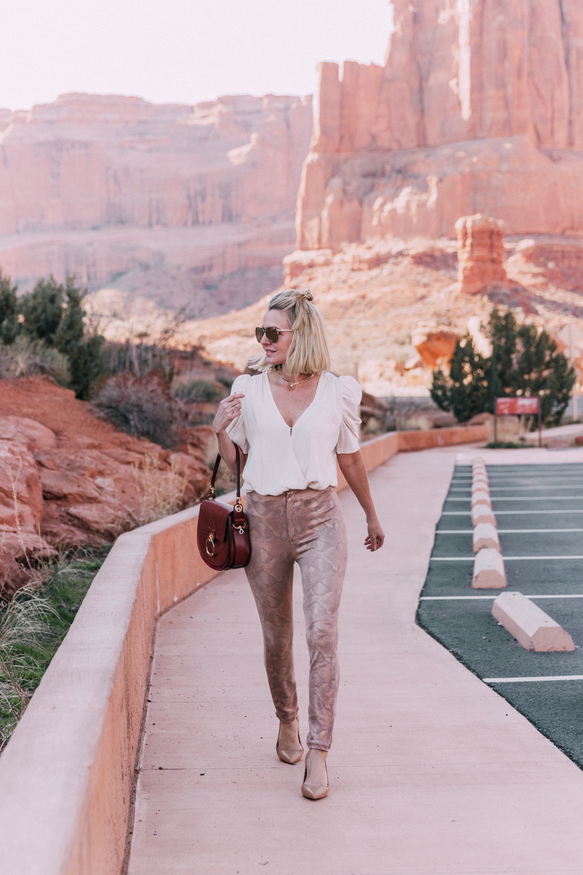 How To Wear Animal Prints, Fashion blogger Erin Busbee of BusbeeStyle.com wearing a white ruched sleeve bodysuit by ASTR The Label with Mother snake print pants from Revolve in Moab, Utah