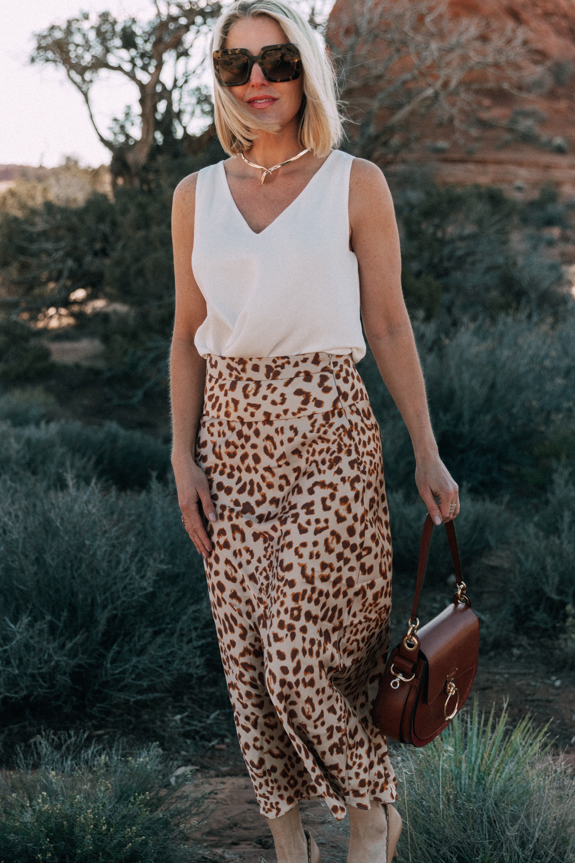 How To Wear Animal Prints, Fashion blogger Erin Busbee of BusbeeStyle.com wearing a white AQUA tank from bloomingdale's with a leopard print midi skirt by Free People in Moab, Utah